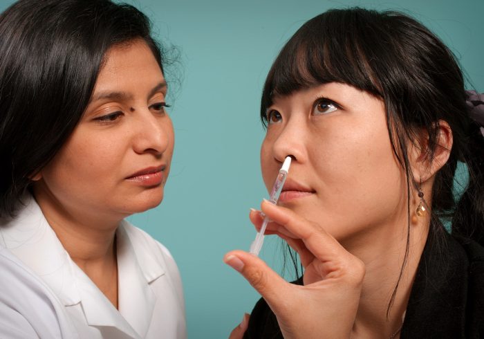 woman holding syringe near woman wearing black top