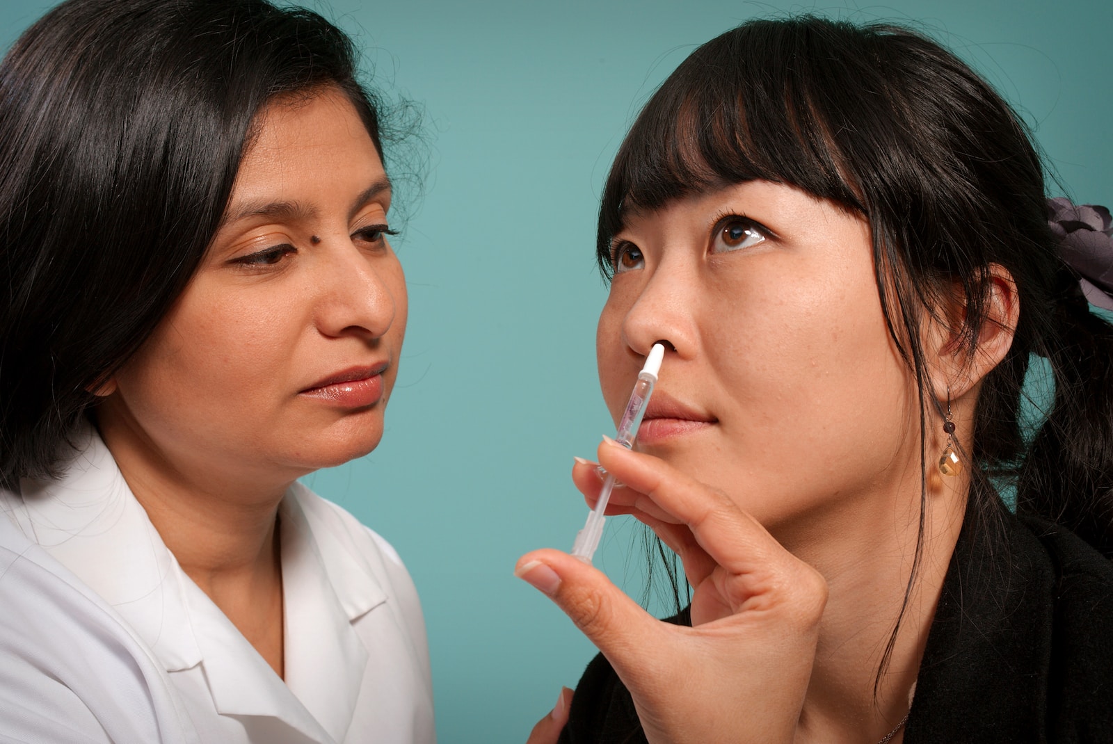 woman holding syringe near woman wearing black top